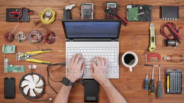 Hombre ingeniero de software que trabaja con un ordenador portátil y un disco duro externo. Vista superior de mesa de madera. Descargar archivos y desconecta el cable — Vídeo de stock