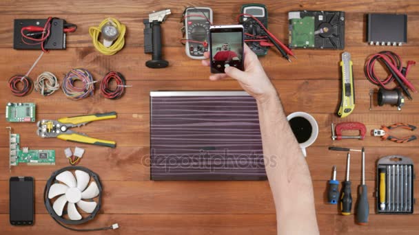 Ingeniero programador masculino hace selfie teléfono. Vista superior de mesa de madera. Herramientas para reparación cerca — Vídeo de stock