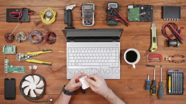 Erkek mühendis programcı bir flash kart kamera bir dizüstü bilgisayarda dosyaları kopyalar. Ahşap masa üstü görünümü. Kart okuyucu kullanır