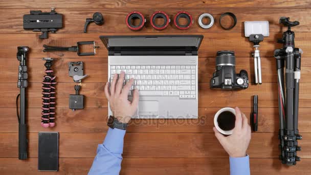 Manos masculinas lente de cámara fotográfica eliminado para la limpieza. Vista superior de mesa de madera. Equipo para disparar sobre la mesa — Vídeo de stock