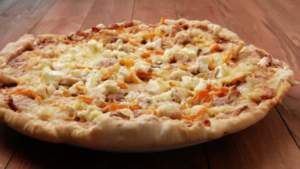 与不同种类的奶酪和西红柿木制的桌子上的自制披萨。移动照相机 — 图库视频影像