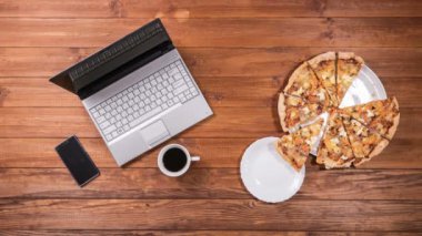 Plaka tüm pizza ayrı bir parça alır. Sonra adam pizza ve laptop için çalışıyor. Stop motion animasyon.