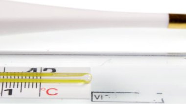 Elektronik termometre beyaz bir masada yatıyor. Kamera kaydırıcıyı hareket. Makro.