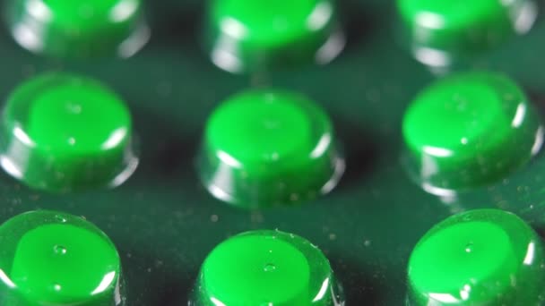 Verpakking tabletten in een groene blister. Macro. Bewegen op de schuifregelaar camera. — Stockvideo