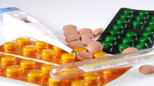 Fond médical : comprimés, thermomètre, stéthoscope reposent sur une table blanche. Caméra en mouvement sur le curseur .