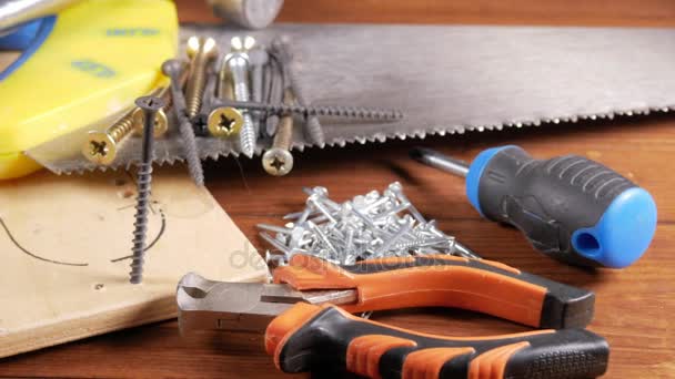 木匠工具躺在一张木桌上。锤子，螺丝刀，钉。树木在一起工作的概念. — 图库视频影像