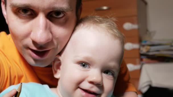 Un beau garçon de 2 ans et un père qui fait des selfies. Souriez et regardez la caméra à la maison . — Video