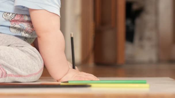 Egy vonzó, a 2 éves fiú felhívja a színes ceruzák otthon. Ez a fekete, a kezét. — Stock videók