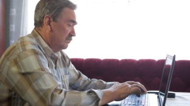 Bıyıklı yaşlı bir adam bir dizüstü oturur ve sorunları çözer. O cidden ekrana görünüyor