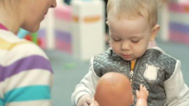 Sevimli sarışın bebek alışveriş merkezinde oyuncaklarla oynuyor. Ne zaman alışveriş çocuk bırakmak çocuk alanı