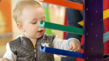 Sevimli sarışın bebek alışveriş merkezinde oyuncaklarla oynuyor. Ne zaman alışveriş çocuk bırakmak çocuk alanı
