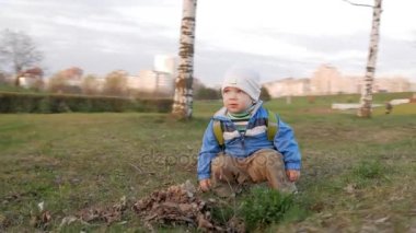 Güzel bir çocuk parkta günbatımında annesi ile oynuyor. Oturuyor, sonra o alır. Kamera çocuk döner