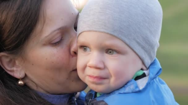 Egy fiatal anya megnyugtatja a babát a park. Hogy a fiú 2 év. Közeli kép: — Stock videók