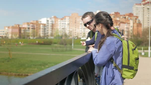 Ung familj matar ankor i en park nära sjön. Den lilla pojken som hjälper till att kasta mat för fåglar i vattnet. — Stockvideo