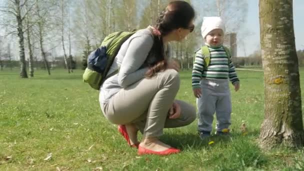 Petit garçon jouant dans le parc avec maman au printemps. Il court et regarde autour de lui. Caméra mobile — Video