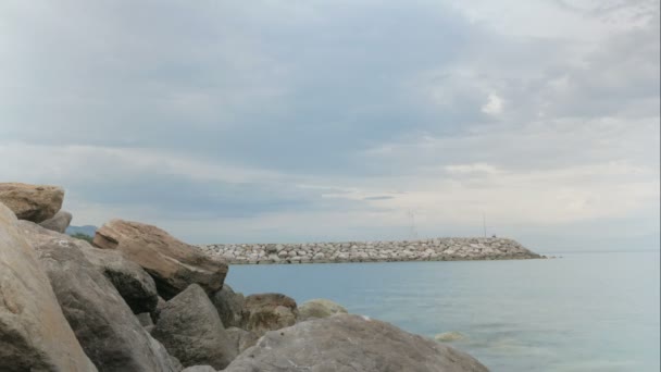 De pier van de steen aan de zee. Mensen lopen langs het snel, wolken drijven. Timelapse — Stockvideo