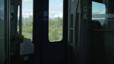 Tren içinde hareket. Dışarıda, parlak bir güneş ve manzara, içeride karanlık
