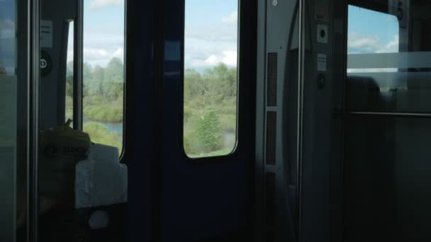 Flytta tåg inuti. Utanför, en strålande sol och landskap, insidan är mörk — Stockvideo