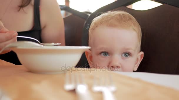 Maman nourrit le mignon petit garçon avec une cuillerée de café. Blonde garçon dans un t-shirt vert — Video