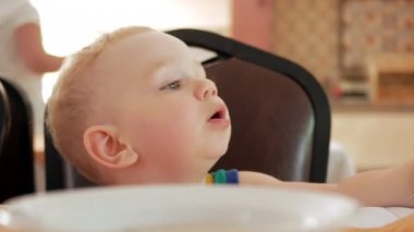 Kafede oturan ve gıda için bekliyor şirin yürümeye başlayan çocuk. Ziyaretçileri değerlendirmeleri