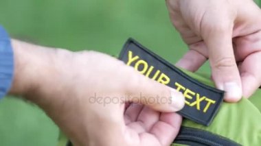Mens eller bir yeşil sırt çantası kelime Sayın metin Velcro sarılmak. Yakın çekim