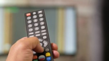A el tutar TV uzaktan mans ve kanal geçiş yapar. Yakın çekim, hareketli kamera