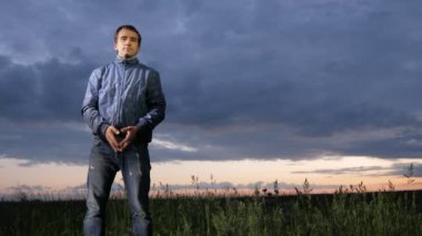 Kameraya batımını sahada yakışıklı delikanlı. Bir arka plan üzerinde güzel gökyüzü.