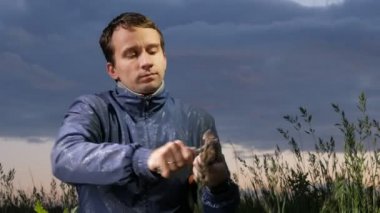 Adam ahşap-yün yangın günbatımında sahada başlatmak için av bıçağı ile hazırlar. Ahşap tıraş. Hayatta kalma kavramı