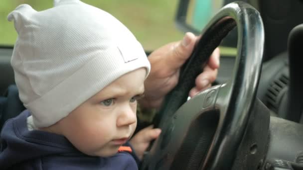 Grand-père joue avec le garçon dans la voiture en conduisant. Le petit-fils est très heureux et tord les différents boutons — Video