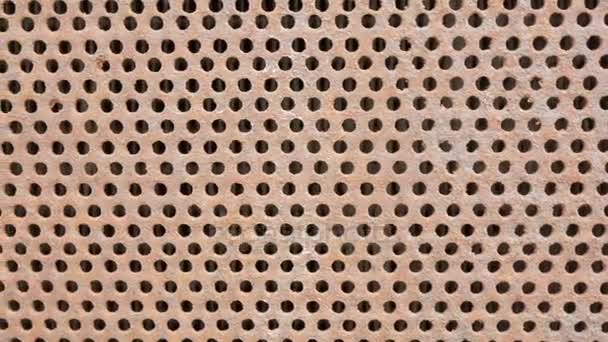 Arrière-plan Calandre rouillée en métal. Des trous symétriques sur toute la surface de la feuille. Caméra mobile 