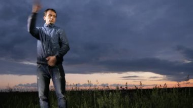 Sevimli genç bir adam sivrisinekler sahada günbatımında dalgalar. Bir arka plan üzerinde güzel gökyüzü.