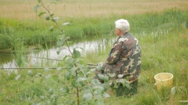 Yaşlı bir adam küçük bir nehir üzerinde yaz aylarında balık tutuyor. Bir olta ve solucanlar kullanır. Orman ve yüksek yeşil çimen