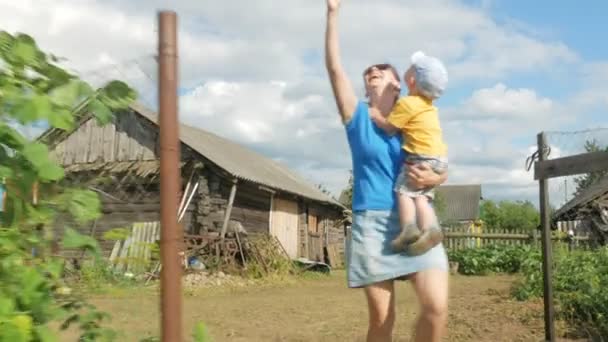 Mladá matka s dítětem zahajuje náporové draka v zelené louce v létě. Matka nemá dělat dobře. Velmi šťastný a syn — Stock video