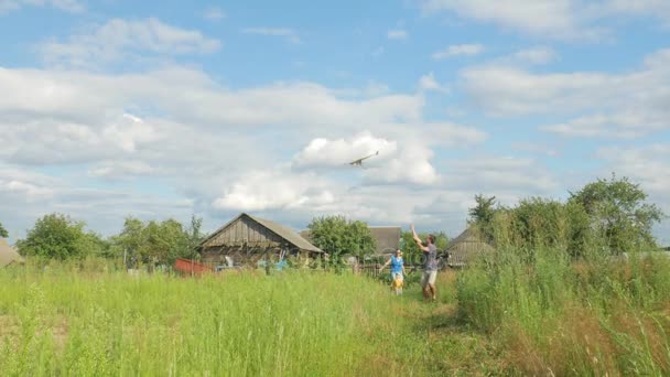 Familia feliz corriendo con una cometa en hierba verde a la cámara. Madre, padre y bebé 2 años en verano — Vídeos de Stock