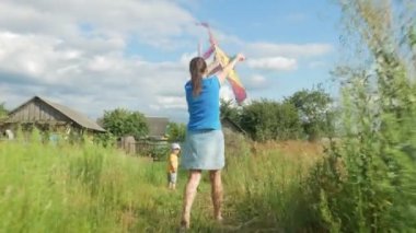 Genç bir anne bebek yeşil bir alanda bir hava uçurtma yaz aylarında başlattı. Annesi de iş yapıyor. Oğlum çok mutlu