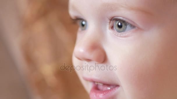 Un niño lindo mira atentamente en un momento dado. Sonriendo y sorprendido por lo que vio — Vídeos de Stock