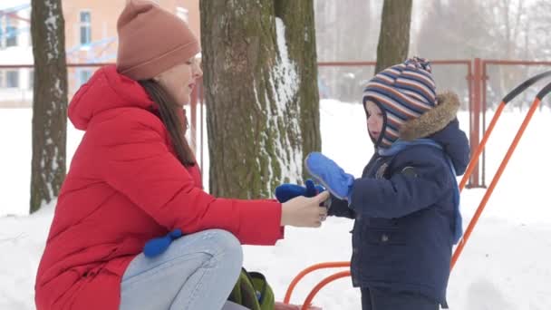 かわいい小さな少年や青年母遊び冬の公園で雪に。青い子供ジャケットと赤のお母さん. — ストック動画
