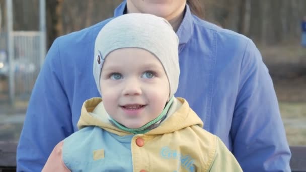 Mãe e bebê estão jogando alegremente provocar durante o sol suave do pôr do sol. Ao ar livre de natural . — Vídeo de Stock