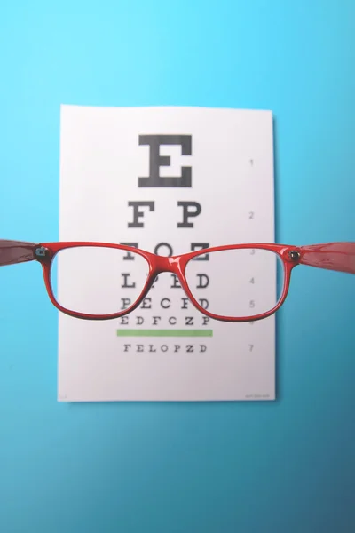 Glasögon liggande på snellen test diagram — Stockfoto