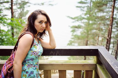 park ve gülümseyen ahşap merdivenlerde oturan kız