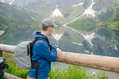 Adam gölde ve dağlarda dinleniyor. Güneşli manzara.