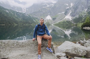 Adam gölde ve dağlarda dinleniyor. Güneşli manzara.