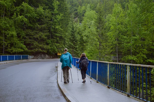 Mulher caminhando sobre ponte de madeira — Fotografia de Stock