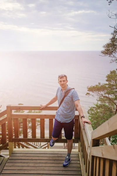 Mann sitzt auf Holztreppe im Park und lächelt — Stockfoto