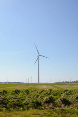 Parlak mavi gökyüzü hareket ediyor ve rüzgar türbini