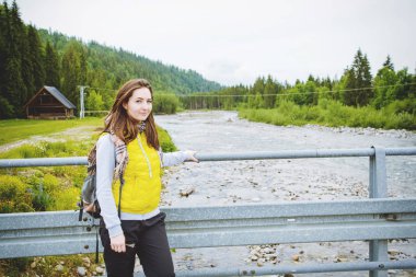 Kadın turist dağ nehir kenarında duran