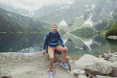 Adam gölde ve dağlarda dinleniyor. Güneşli manzara.