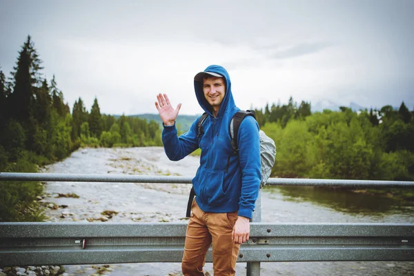 Male tourist standing beside the mountain river — Stock Photo, Image