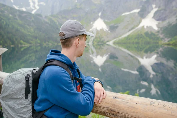 Uomo rilassante sul lago e sulle montagne paesaggio soleggiato — Foto Stock