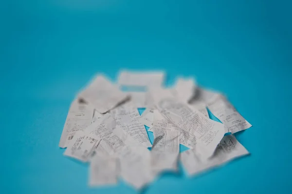Pile of shopping receipts on blue background — Stock Photo, Image